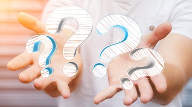 Elle çizilmiş soru işaretleri elinde tutan işadamı