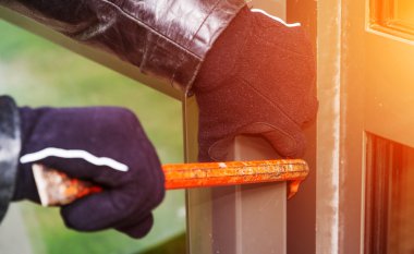 Bir evde kırma deri ceket giyen hırsız