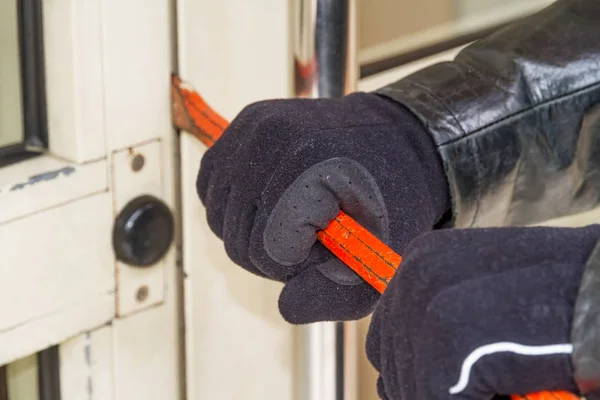 Burglar wearing leather coat breaking in a house — Stock Photo, Image