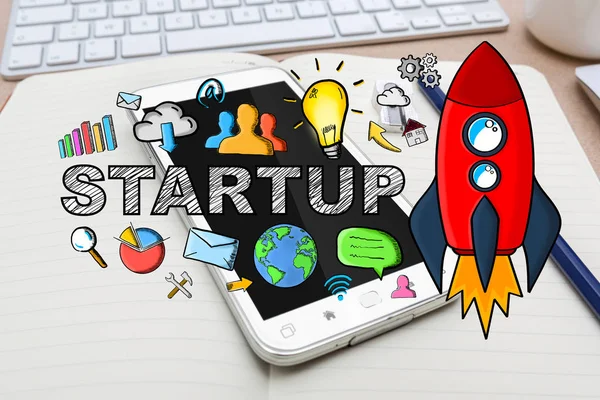 Hand drawn startup text with icons on office background — Stock Photo, Image