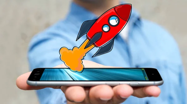 Бизнесмен держит ракету с красной рукой над своим мобильным телефоном — стоковое фото