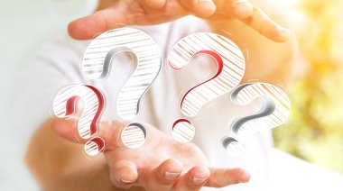 Elle çizilmiş soru işaretleri elinde tutan işadamı