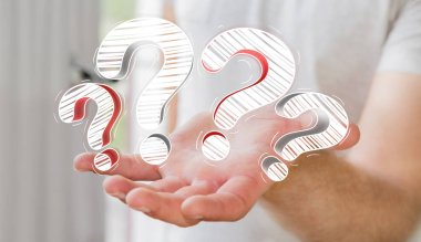 Elle çizilmiş soru işaretleri elinde tutan işadamı