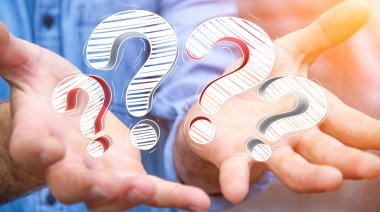 Elle çizilmiş soru işaretleri elinde tutan işadamı