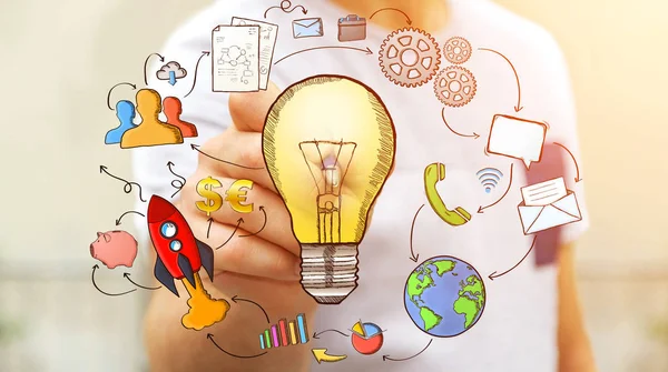 Empresário desenhando uma lâmpada com uma caneta com ícones multimídia — Fotografia de Stock