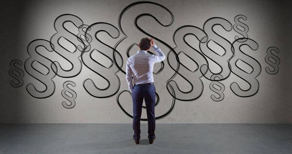 Бизнесмен смотрит символ параграфа закона на стене 3D рендеринга
