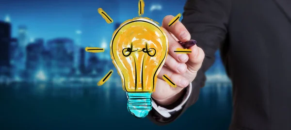 Businessman drawing a lightbulb sketch — Stock Photo, Image