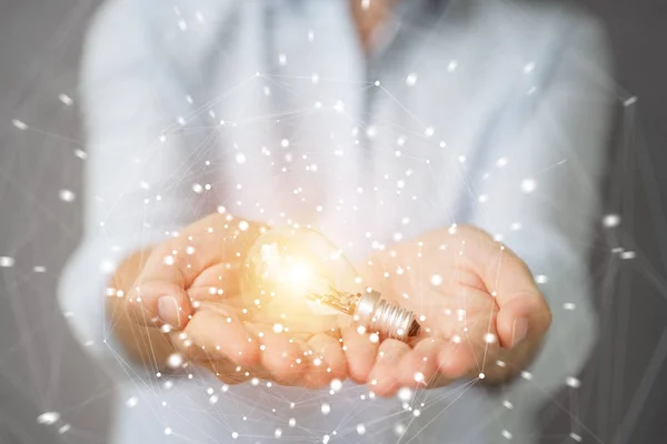 Businesswoman holding a lighbulb with connections in her hand — Stock Photo, Image