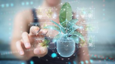 Woman holding and touching holographic projection of a plant wit