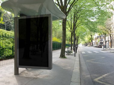 Paris 'te boş bir caddede siyah otobüs durağı afiş modeli. Paris tarzı reklamlar güzel bir şehrin parkına yakın bir yerde.