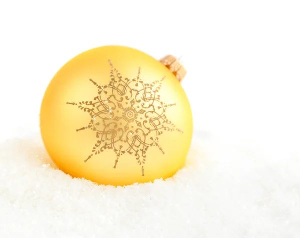 Christmas golden ball with ornament snowflake on snow on a white background — Stock Photo, Image