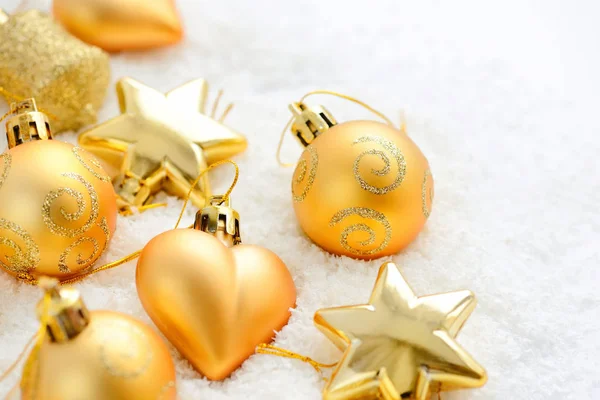 Weihnachten Goldschmuck auf dem Schnee. festlicher weihnachtlicher Hintergrund — Stockfoto