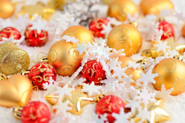 Weihnachtsgold und roter Schmuck auf dem Schnee. festlicher weihnachtlicher Hintergrund — Stockfoto