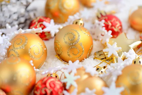 Oro navideño y adornos rojos en la nieve. Fondo navideño festivo —  Fotos de Stock