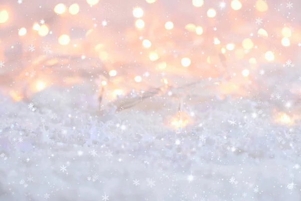 Vánoční světla s sněhové vločky na sněhu. Slavnostní vánoční pozadí — Stock fotografie