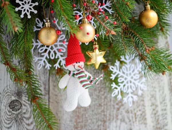 Schneemann mit Weihnachtsschmuck auf den Ästen der Fichte — Stockfoto