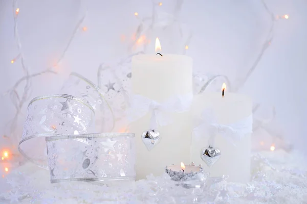 Candele di Natale sulla neve e luci di Natale. Sfondo natalizio festivo — Foto Stock