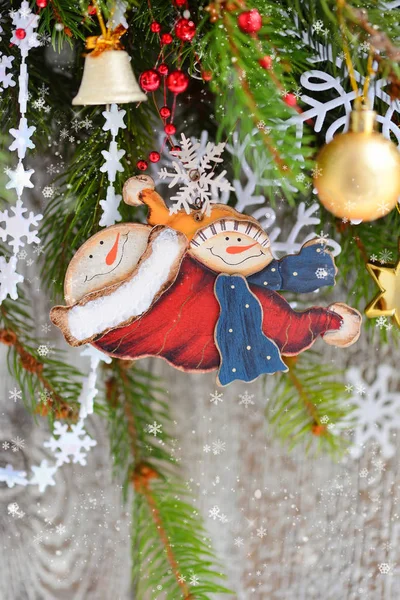 Pupazzo di neve con ornamenti natalizi sui rami di abete rosso — Foto Stock
