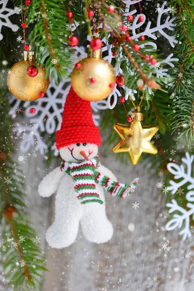 Schneemann mit Weihnachtsschmuck auf den Ästen der Fichte — Stockfoto