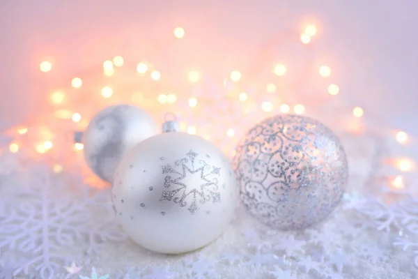 Weihnachtskugeln auf Schnee und Weihnachtsbeleuchtung. festlicher weihnachtlicher Hintergrund — Stockfoto