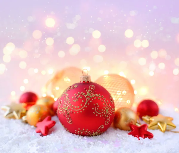 Decoraciones navideñas sobre nieve y luces navideñas. Fondo navideño festivo —  Fotos de Stock