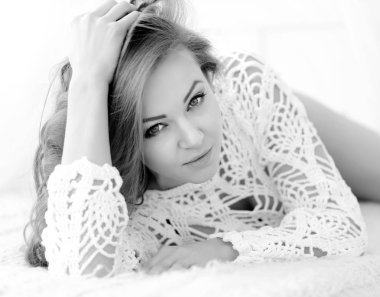 Güzel kadın evde yatağında yatarken. Baştan çıkarıcı beyaz kameraya görünüyor.