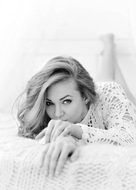 Güzel kadın evde yatağında yatarken. Baştan çıkarıcı beyaz kameraya görünüyor.