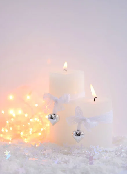 Velas de Navidad en la nieve y luces de Navidad. Fondo navideño festivo —  Fotos de Stock