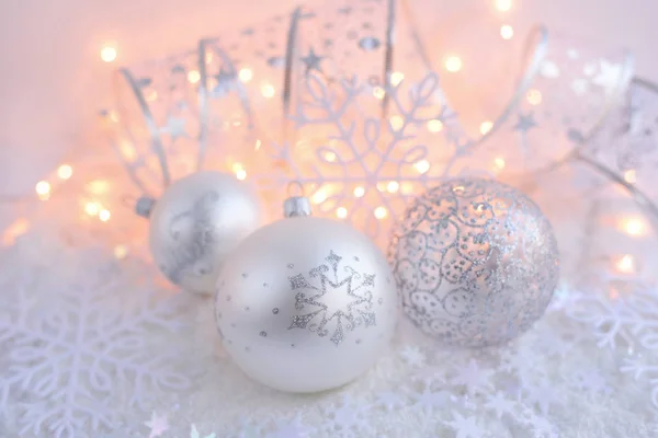 Bolas decorativas navideñas sobre nieve y luces navideñas. Fondo navideño festivo — Foto de Stock