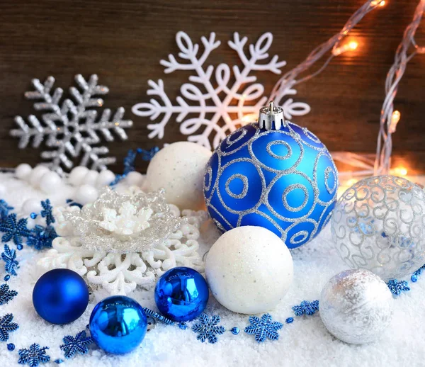 Decoratieve kerstballen op sneeuw en kerstverlichting. Feestelijke Kerstmis achtergrond — Stockfoto