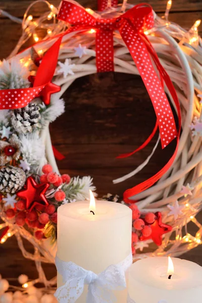 Velas blancas en la nieve con corona de Navidad y luces de Navidad. Fondo navideño festivo — Foto de Stock