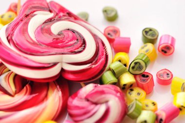 Renkli şekerler ve beyaz bir arka plan üzerinde lolipop