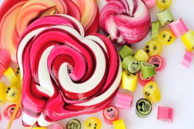 Renkli şekerler ve beyaz bir arka plan üzerinde lolipop