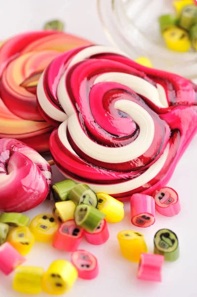 Caramelle colorate e lecca-lecca su sfondo bianco — Foto Stock