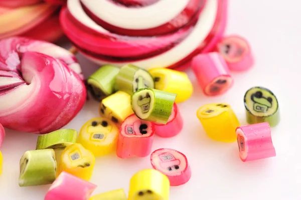 Renkli şekerler ve beyaz bir arka plan üzerinde lolipop — Stok fotoğraf