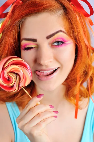 Gyönyörű nő a gazdaság egy cukorkát kreatív smink — Stock Fotó