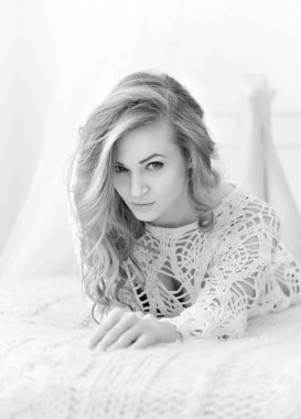 Güzel kadın evde yatağında yatarken. Baştan çıkarıcı beyaz kameraya görünüyor.