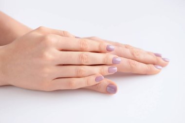 Elinde çivi beyaz arka plan üzerinde pembe manikür genç bir kadınla closeup