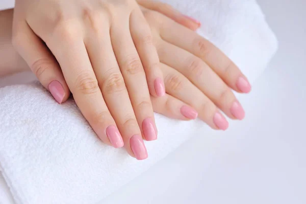 Ruce ženy s růžovými manikúra jsou na ručník — Stock fotografie