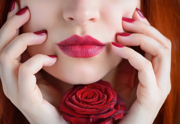 Arckép piros rózsa virág. Sötét piros ajkak és a körmök. Gyönyörű vörös hajú fiatal nő. — Stock Fotó