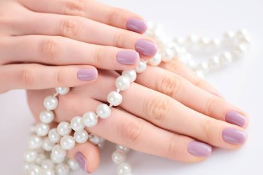 Pembe manikür beyaz inci kolye holding ile genç bir kadın güzel el