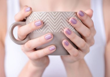 Elleri pembe manikür çay holding ile genç bir kadın