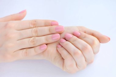 Elinde çivi üzerinde pembe manikür genç bir kadınla closeup
