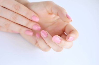 Elinde çivi üzerinde pembe manikür genç bir kadınla closeup