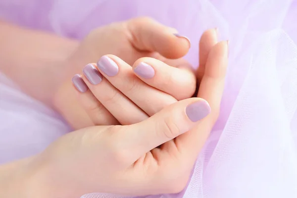 Detailní záběr na ruce mladé ženy s růžová manikúra nehty na pozadí růžové vei — Stock fotografie