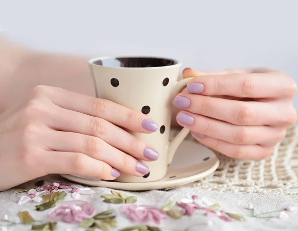 Cup of coffee in girl hands on linen tablecloth — Stock Photo, Image