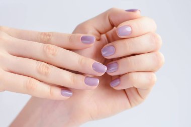 Elinde çivi üzerinde pembe manikür genç bir kadınla closeup