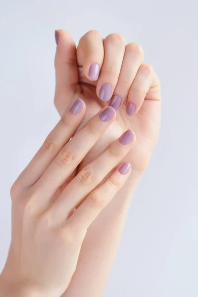 Zbliżenie dłoni młodej kobiety z różowy manicure na paznokcie — Zdjęcie stockowe