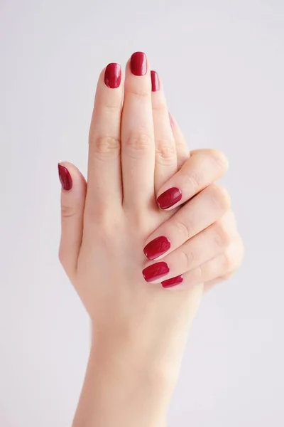 Primer plano de las manos de una joven con manicura roja en las uñas — Foto de Stock