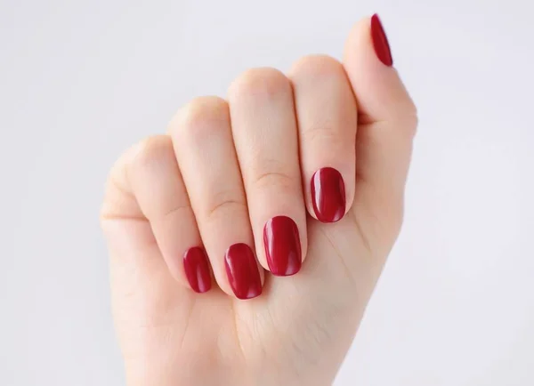 Detailní záběr na ruce mladé ženy s červenými manikúra nehty — Stock fotografie
